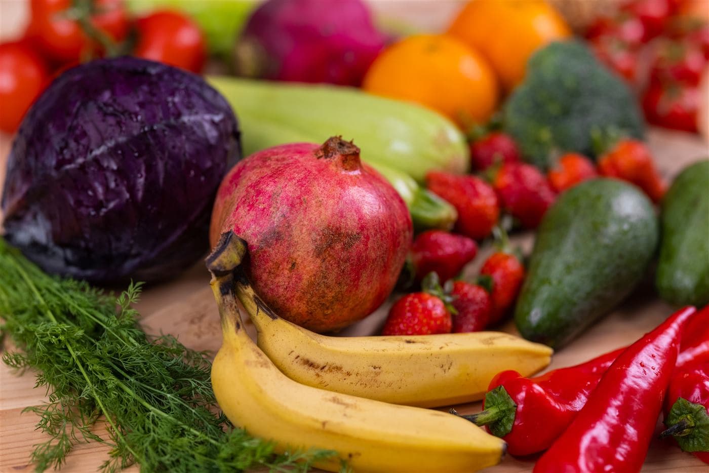 Frutas e verduras frescas e coloridas: repolho-roxo, romã, banana, morangos, pimentas e mais